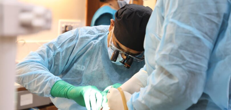 Dentist performing full arch implant training on a live patient