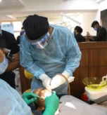 Dentist in a dental implant clinical residency treating a live patient under mentorship