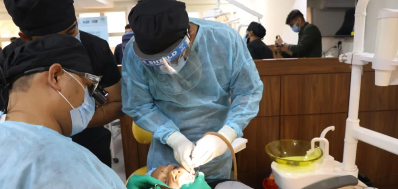 Dentist in a dental implant clinical residency treating a live patient under mentorship